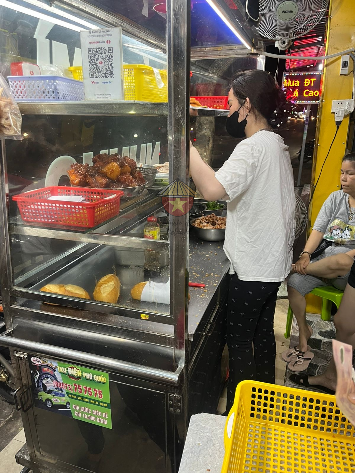 Puesto de Banh Mi La trabajadora preparando un Banh Mi