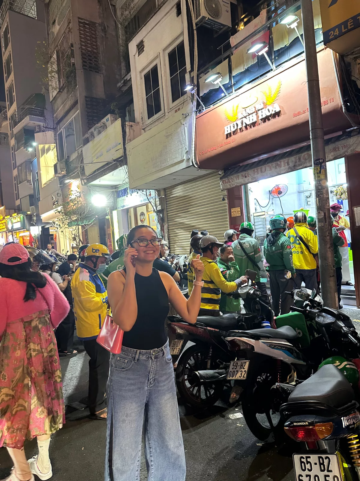 Muoi posando junto a la entrada de este restaurante