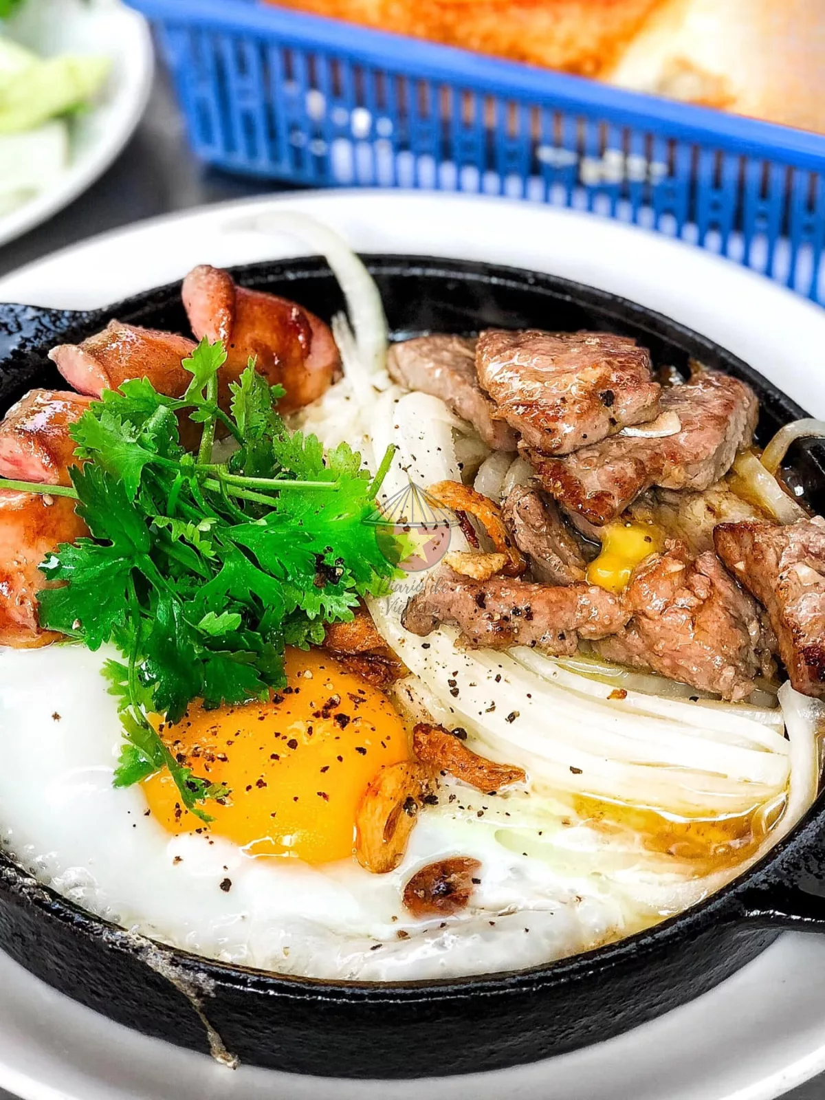 Sartén caliente de carne, huevo, ajo y mantequilla. Acompañado de pan.