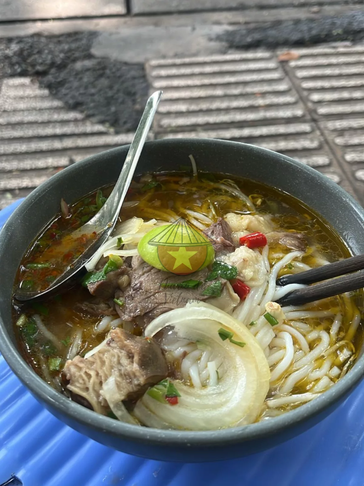 Caldo picante y aromático con hierba de limón, chile y pasta de camarones. También lleva fideos gruesos de arroz, carne de res y cerdo, y se sirve con hierbas frescas, brotes de soja, lima y chile.